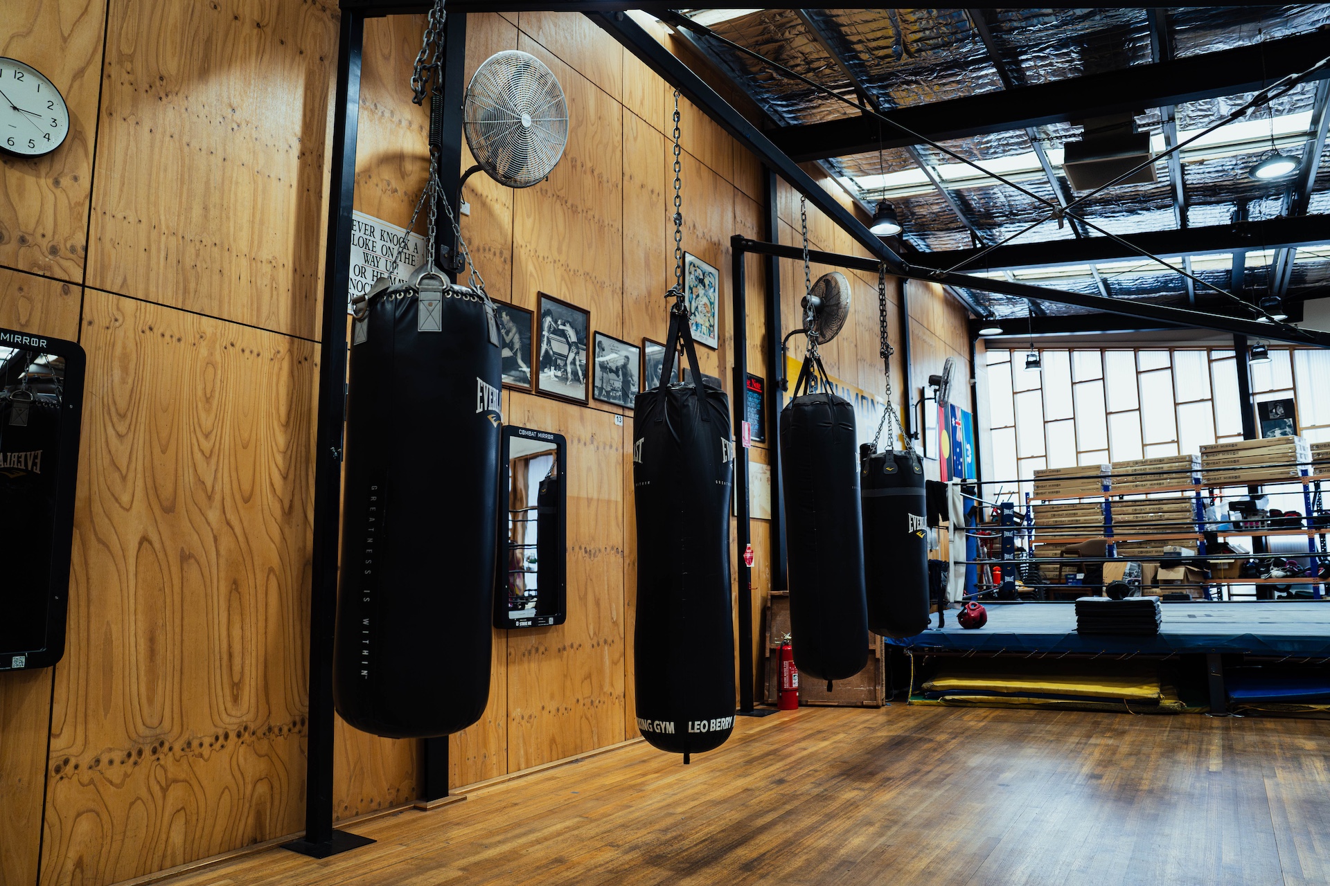Row of Everlast heavy bags along the timber wall of the gym