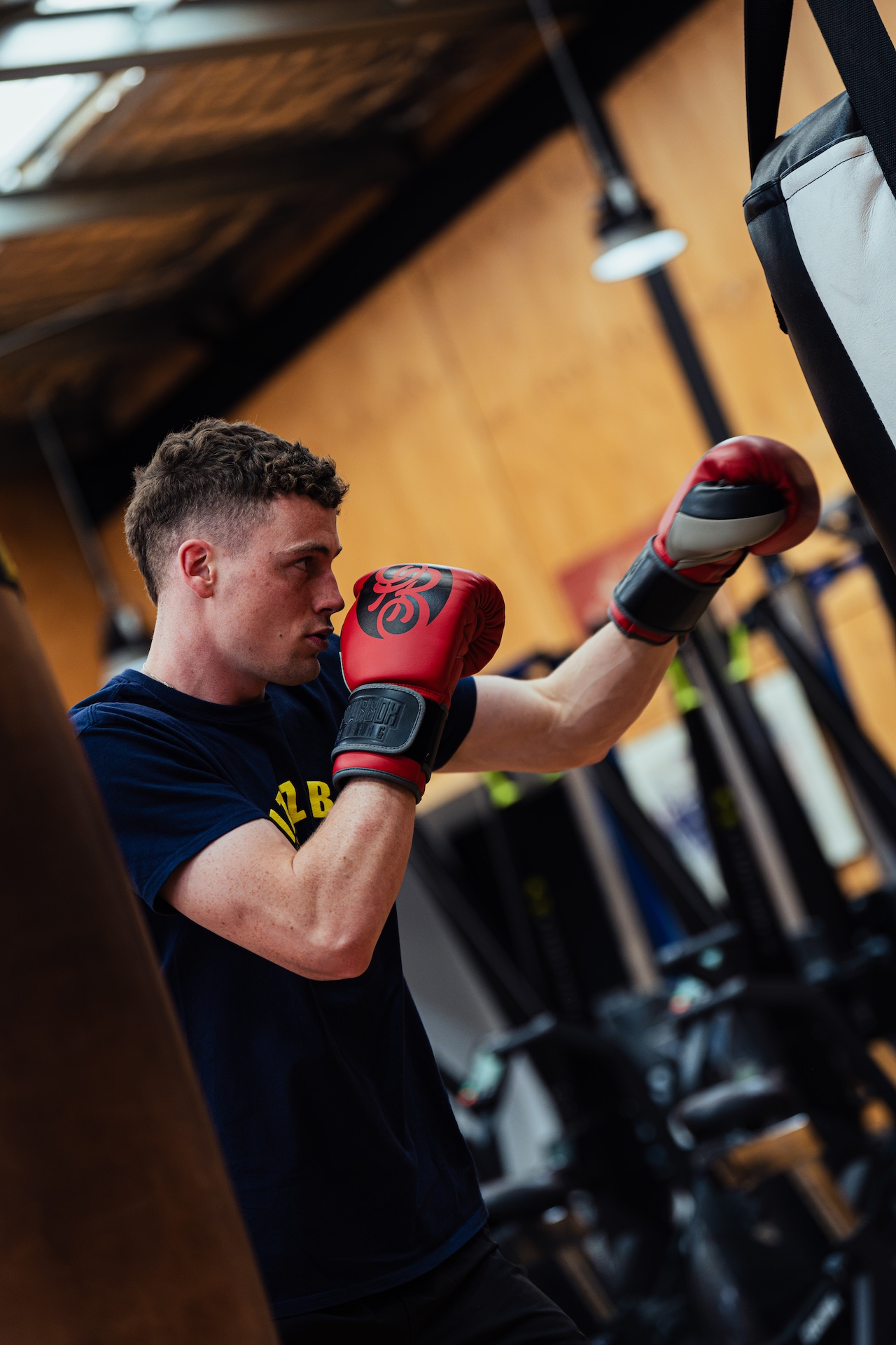 Boxer working the heavy bag in red gloves at Leo Berry's Gym